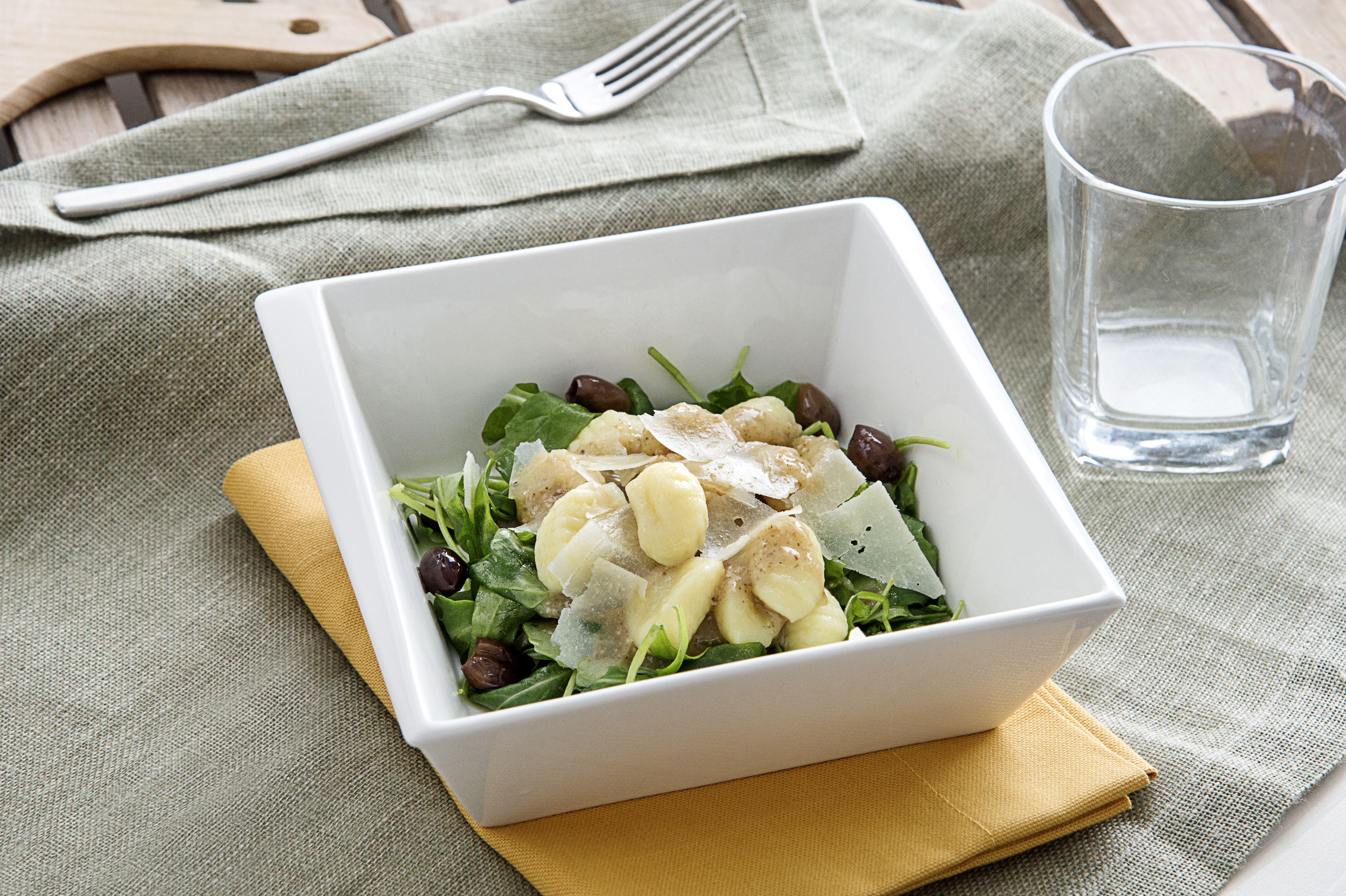 Gluten-free potato gnocchi with walnut pesto, fresh arugula and pecorino flakes