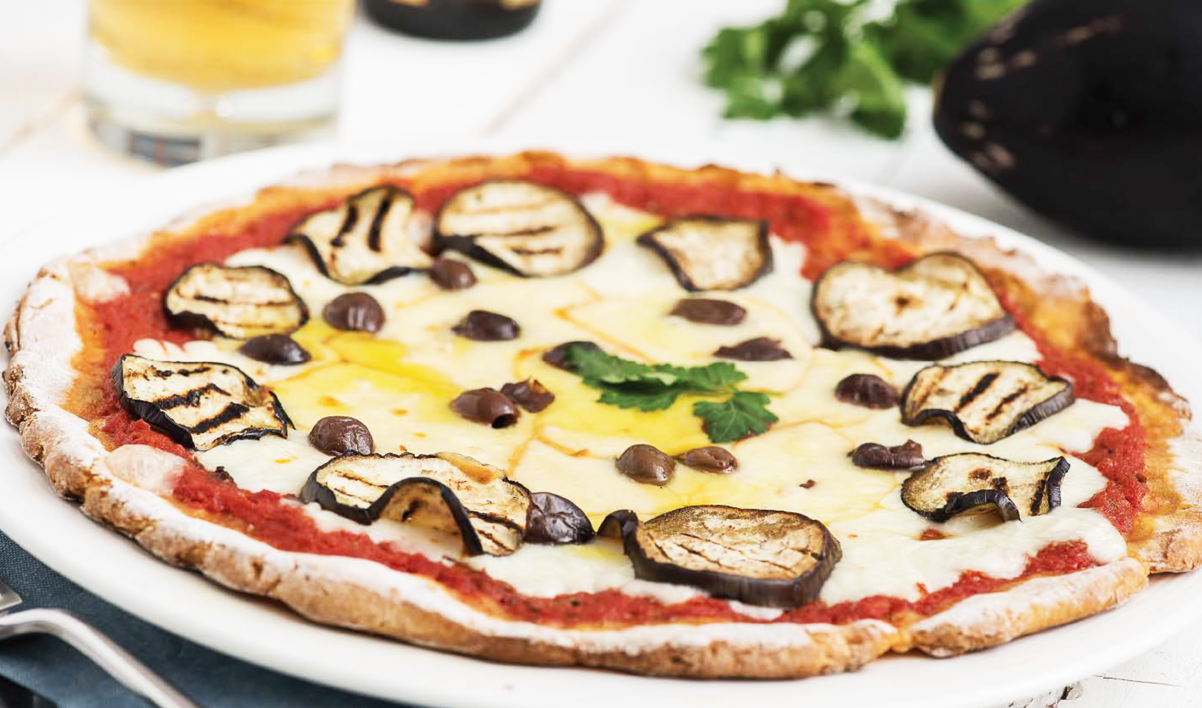 Pizza di fonio senza glutine con scamorza, olive e melanzane grigliate