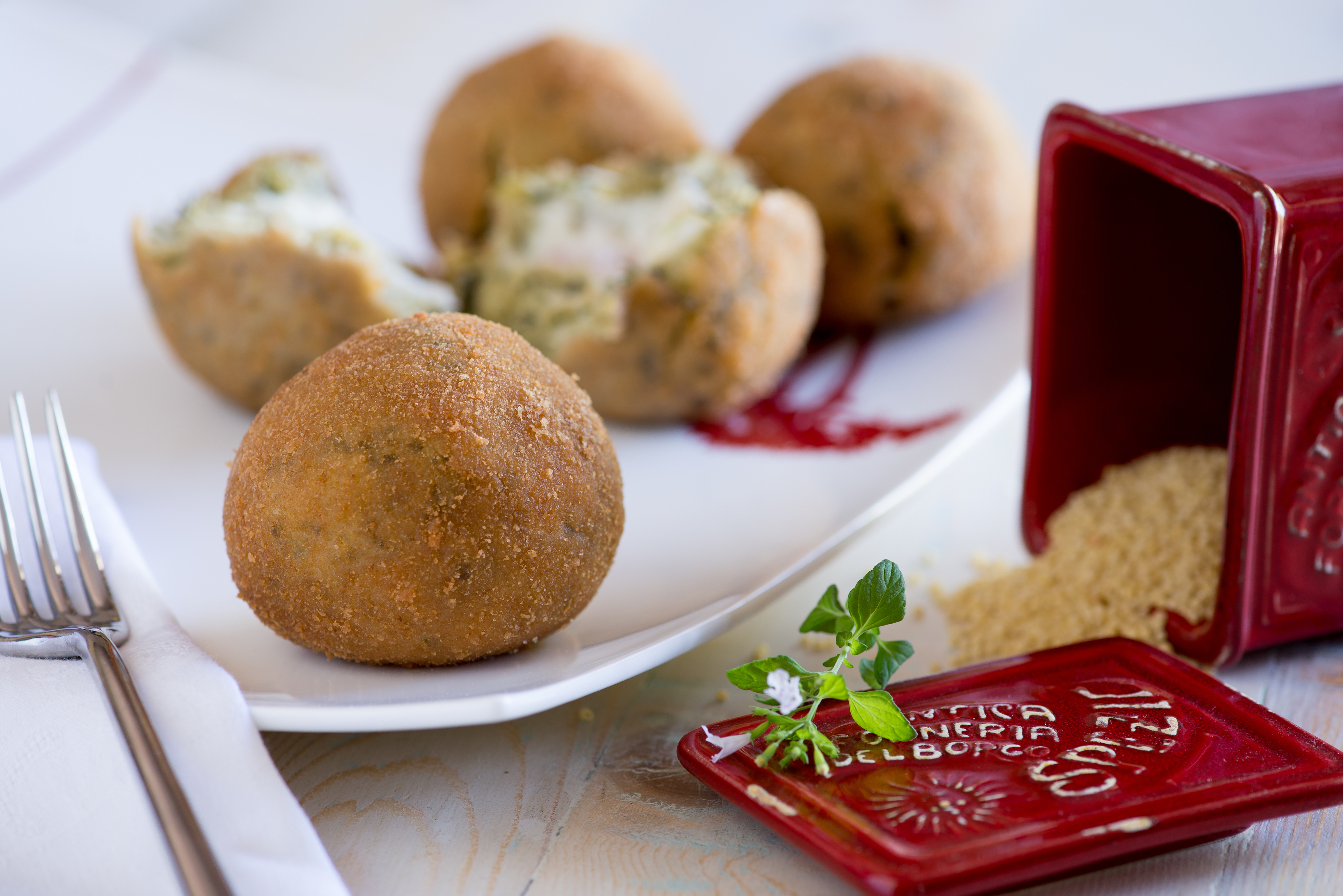 Arancina di miglio senza glutine con cime di rapa, pancetta scamorza e besciamella