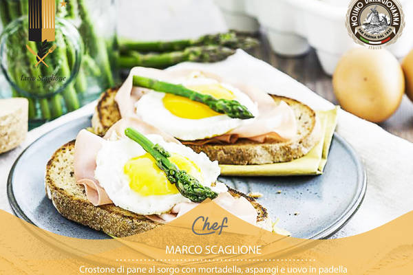 Gluten-free crostone with mortadella, asparagus and egg in a pan