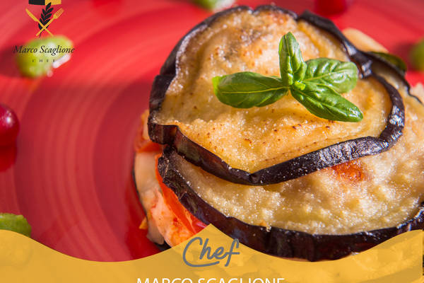 Parmigiana di melanzane con filetti di nasello alla grappa, provolone piccante e riduzione di piselli